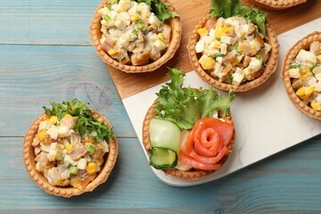 Tartlets with delicious fillings on blue wooden table, top view