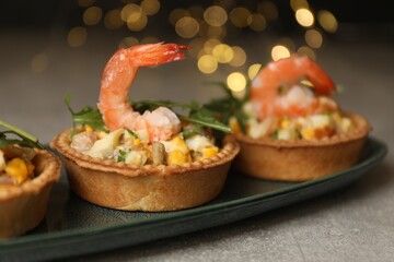 Tartlets with delicious filling on grey table, closeup. Bokeh effect