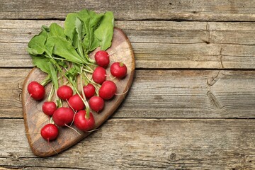 Many fresh radishes on wooden table, top view. Space for text