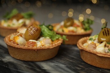 Tartlets with delicious filling on table, closeup. Bokeh effect