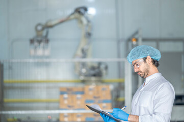 A quality control specialist in a modern factory inspects production processes while recording data...