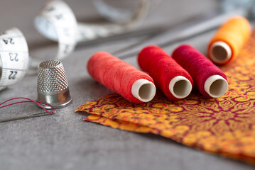 Sewing kit - colorful yarns, fabric, needle and measuring tape on - close-up