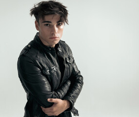 Fototapeta premium seductive young man in leather jacket holding arms crossed