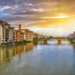 Scenic sunset cityscape over Arno River, St Trinity Bridge and colorful old houses along the river in Florence city