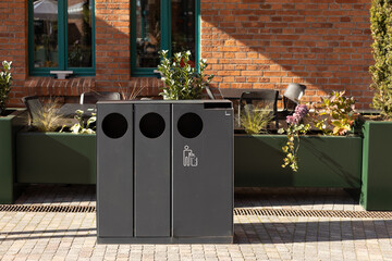 Public black trash can near cafe in city street outdoors. Help to reduce waste, Help global...