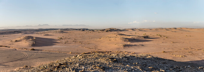 long shadows on sandy desert and rocky hills from above, near Twyfelfontein, Namibia