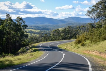 Fototapeta premium A long and curvy road winding through the mountains on a sunny day