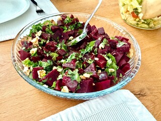 Homemade healthy beetroot salad or beet with fresh greens and walnut