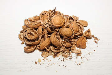 A pile of walnut shells on a white table.