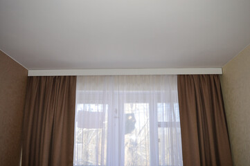 window with brown blackout curtains and a sheer white curtain minimalist curtain rod cover modern cozy design room real estate rental listings window treatment decor living space apartment sheer 