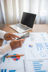 Fototapeta premium A young Asian businessman is examining financial documents to determine investment returns and analyze investment risks.