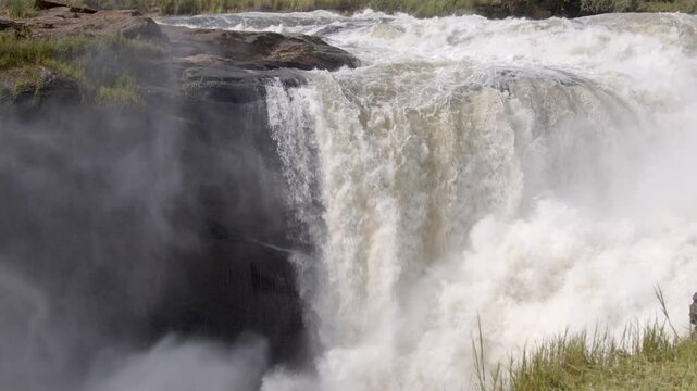 Slow motion panning shot of Murchison Falls in Uganda, where the Nile River flows through a narrow gap.