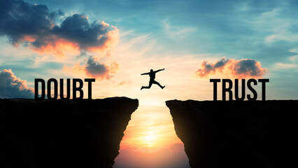 Silhouette of a person jumping from doubt to trust over a gap between cliffs at sunset, overcoming fear, building confidence, making a leap of faith, believing in oneself, achieving personal growth 