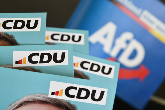 Burgdorf, Lower Saxony, Germany - February 19, 2025: Flyers of The Christian Democratic Union of Germany with the CDU logo - AFD logo in the background
