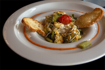 Starter based on sautéed vegetables with egg and eel