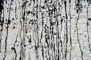 A wall with black and white paint splatters, creating a textured