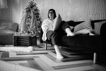 Portrait of a young beautiful plump short-haired girl in the studio. Black and white photo.