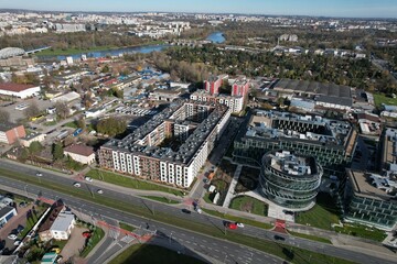 An aerial view of Kraków’s Zabłocie district, showcasing its dynamic transformation along the banks of the Vistula River. Once an industrial area, Zabłocie has evolved into a modern, thriving neighbor