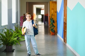 Portrait confident schoolboy in school corridor