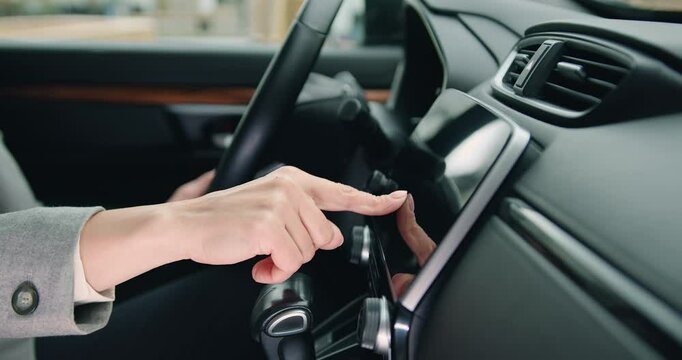 Female hand touches navigation on car monitor screen Close up of woman hand driver entering an address into the navigation system in modern car.