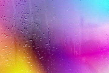Colorful Water Droplets: A vibrant display of water droplets on a glass surface, reflecting a spectrum of colors that evoke a sense of wonder and serenity.Raindrops on a glass window with a colorful p