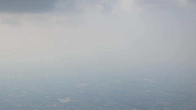 Aerial view of Environmental issue of air pollution pm 2.5 over sky of Bangkok metropolis from flying areoplane aircraft's window.