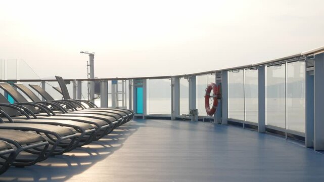 empty lounge chairs on sundecks of the cruise ship while cruising in the international open sea in asia in summer holiday vacation time.