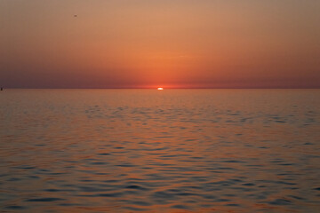 Fototapeta premium sunset on the background of the sea sky, Sunset sky, clouds over the sea in the evening with orange, yellow sunlight, Golden hour
