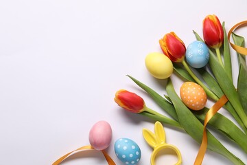 Easter eggs, beautiful tulips and bunny figure on white background, flat lay. Space for text