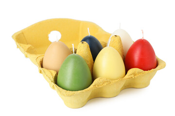 Colorful egg-shaped candles in carton isolated on white. Easter decor