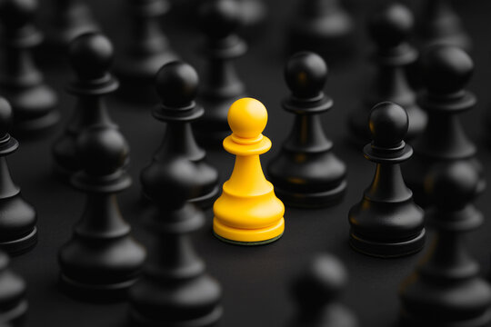 The Golden Pawn: An intriguing macro shot highlights a single, striking yellow pawn amongst a sea of black chess pieces, symbolizing uniqueness and strategic advantage.