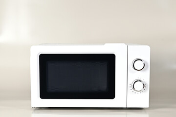 The microwave oven is white on a monochrome insulated background