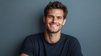 Fototapeta premium Smiling man in black t-shirt on grey background