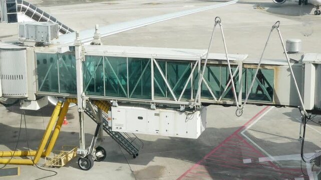 view of Passenger boarding aircraft at airport gate by aerobridge jet bridge or jetway or airbridge to a plane, Passengers goes to airplane through jet bridge.airport ground operation service