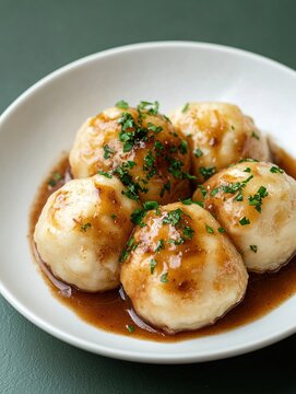 Delicious raspeballer served with rich brown sauce on a smooth white plate