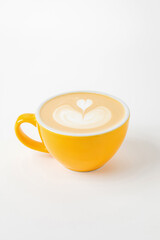 A yellow cup of cappuccino, latte, flat white coffee with latte art