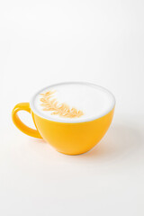 A yellow cup of cappuccino, latte, flat white coffee with latte art