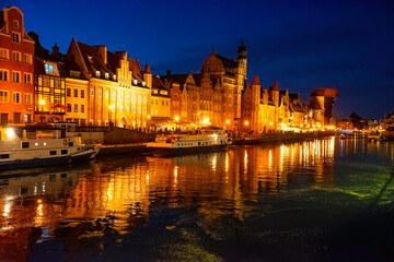 Obraz premium Gdansk old town and famous crane at night. View from Motlawa river. Poland at romantic night. The city also known as Danzig and the city of amber.