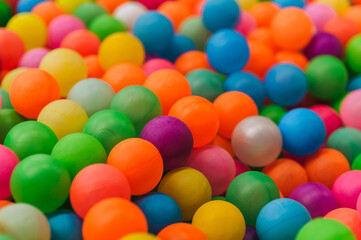 Background of many plastic colorful and multicolored round balls in children's playroom for kids to play. Photography, childhood concept.