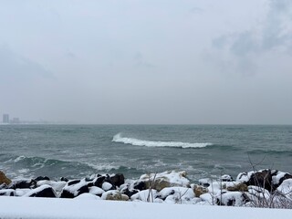 waves on the sea and snow on the rocks on the beach