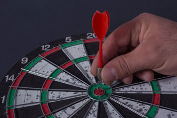 man holding dart arrow hit in target center of dartboard