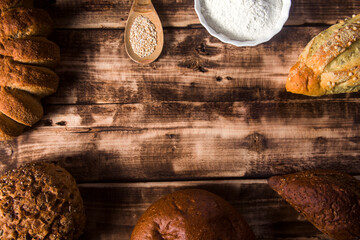 Assortment of baked bread on wooden table background