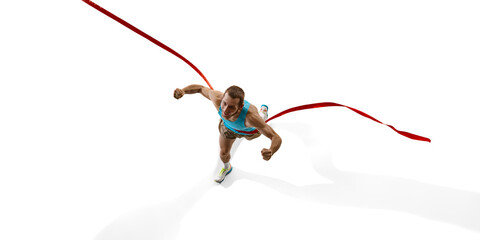 Sprinter breaking red ribbon, clenched fists and with determined face capturing final moment of...