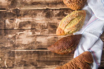 Assortment of baked bread on wooden table background