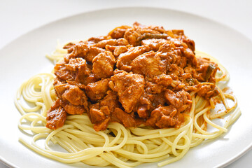 Chicken curry spaghetti on a plate. Fusion food Italian and Indian mixed dishes.
