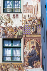 Painted facade with frescoes depicting the history of the city on an old house in the old town of...