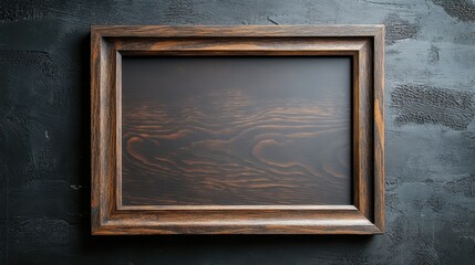 Empty wooden picture frame on dark textured background