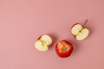 Green red apple, half apple and quarter apple on pink background. Top view, healthy food concept. Top view. High quality photo