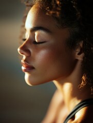 Beautiful young woman in serene pose, eyes closed and breathing deeply, radiating inner peace and tranquility.