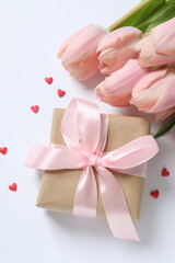 Beautiful fresh tulips with gift box on white background